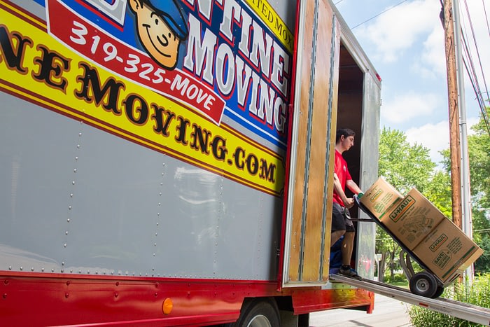 mover uses dolly to unload boxes from moving truck