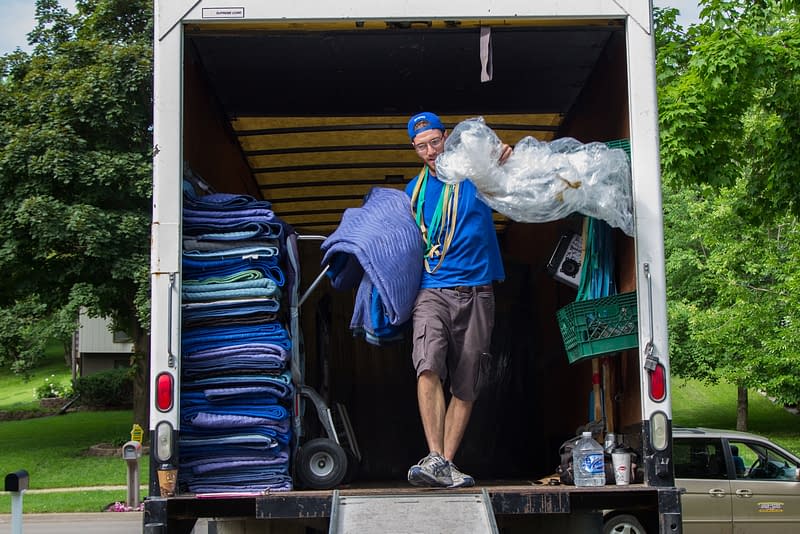 mover unloads blanketing from moving truck