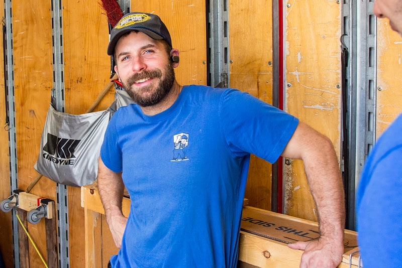 smiling man in blue shirt inside of moving truck