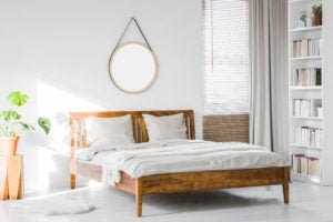A Wooden Rustic Bed Frame And A Home Library Bookcase In A Natur