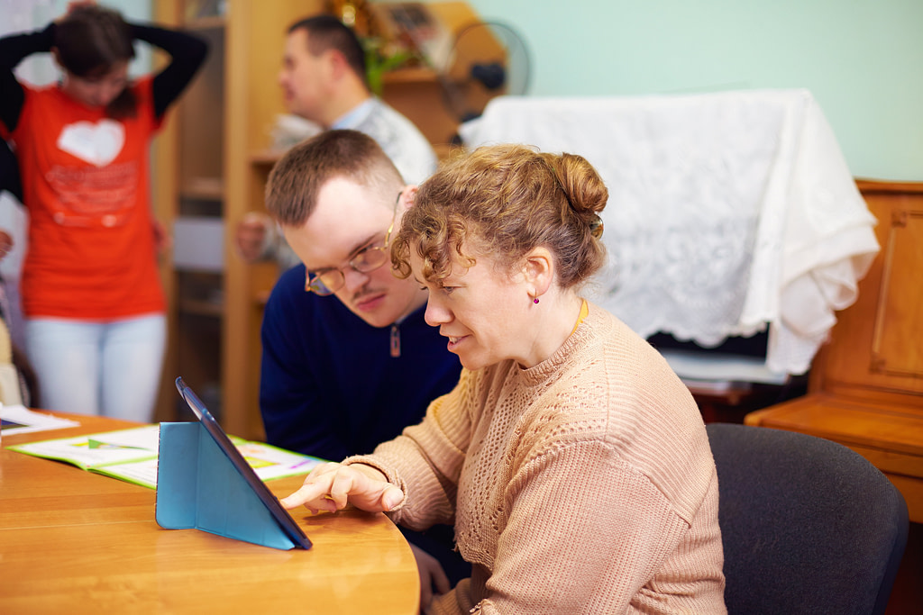Two Friends With Disability In Rehabilitation Center, Watching Digital Tablet