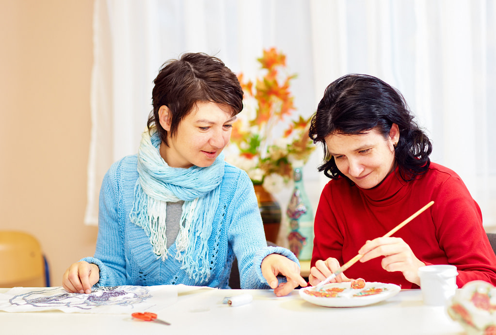 Adult Woman With Special Needs Are Engaged In Handcraft In Rehabilitation Center