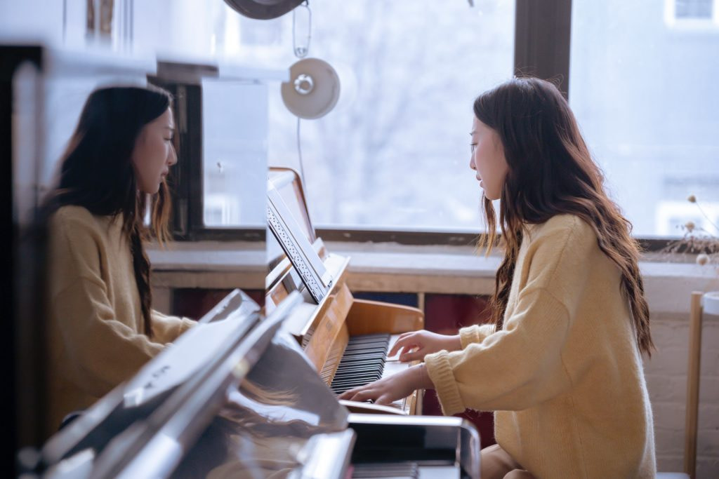 A woman playing a piano on a cold winter morning.