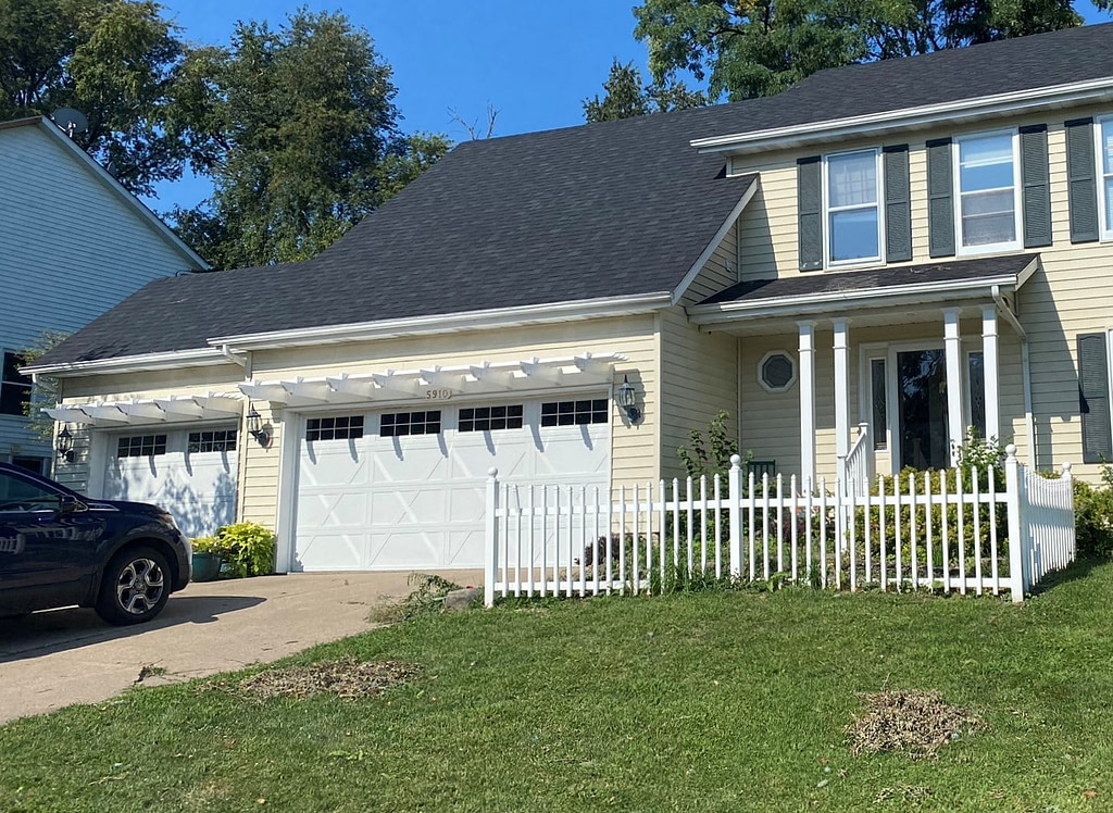 Pergolas over a 3 car garage on yellow house
