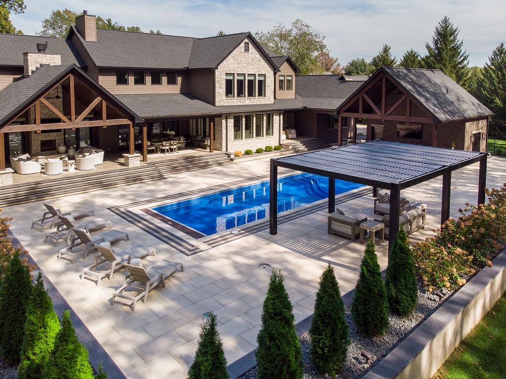 Aerial view of a patio complete with beautifully landscaped pool, pavilion and pergola.