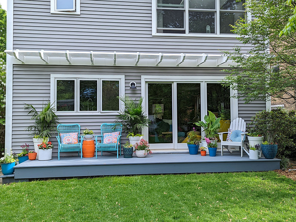straight on view of an eyebrow pergola stretching across the length of the back of a house