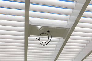 View from under a pergola with outdoor fan mount or mount for lighting on pergola.