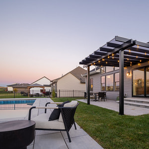 Rain Proof covered pergola over a patio at sunset