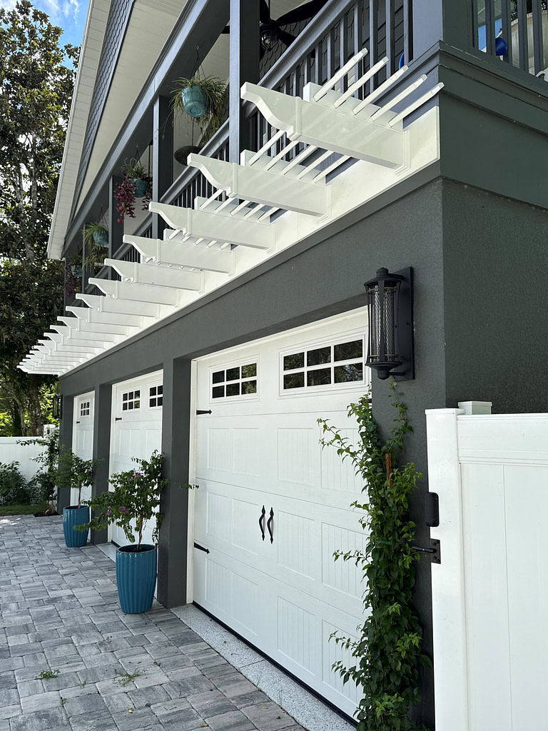 White Vinyl Garage Pergola on a dark gray stucco home