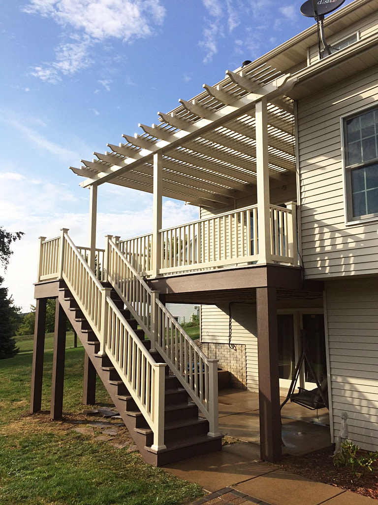 Tan attached shade pergola on a raised deck