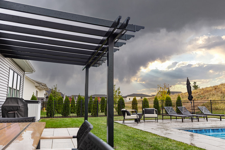 rainy day with a rain proof pergola in a backyard
