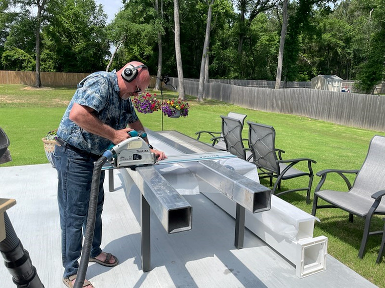 DIY pergola installation man cutting aluminum posts of heartland pergola