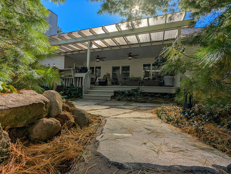 Covered deck with tan pergola and bronze polycarbonate roof