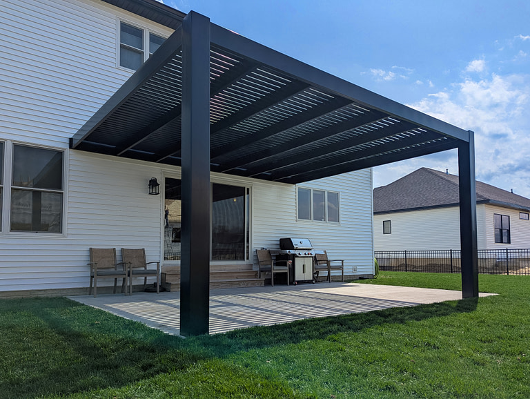 Black attached pergola over a patio space