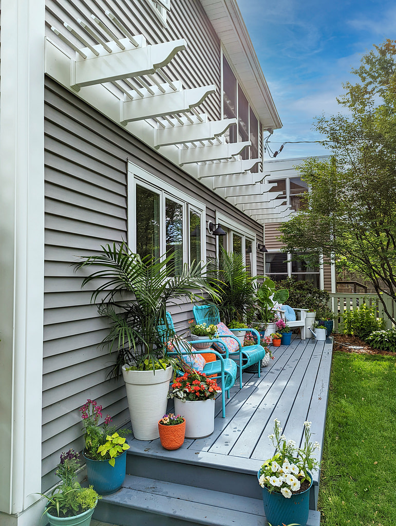 Eyebrow pergolas running the length of a back deck over windows.