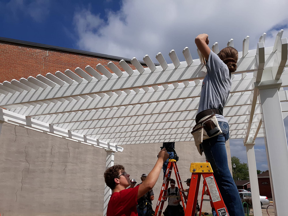 Contractor working on installing shade purlins of a pergola