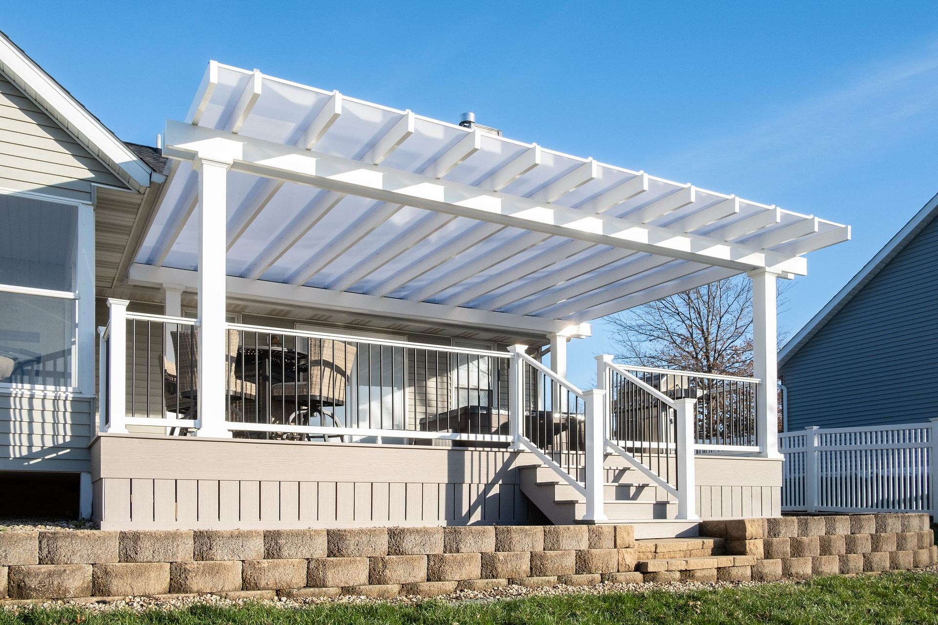 White pergola over a deck with a solid roof.