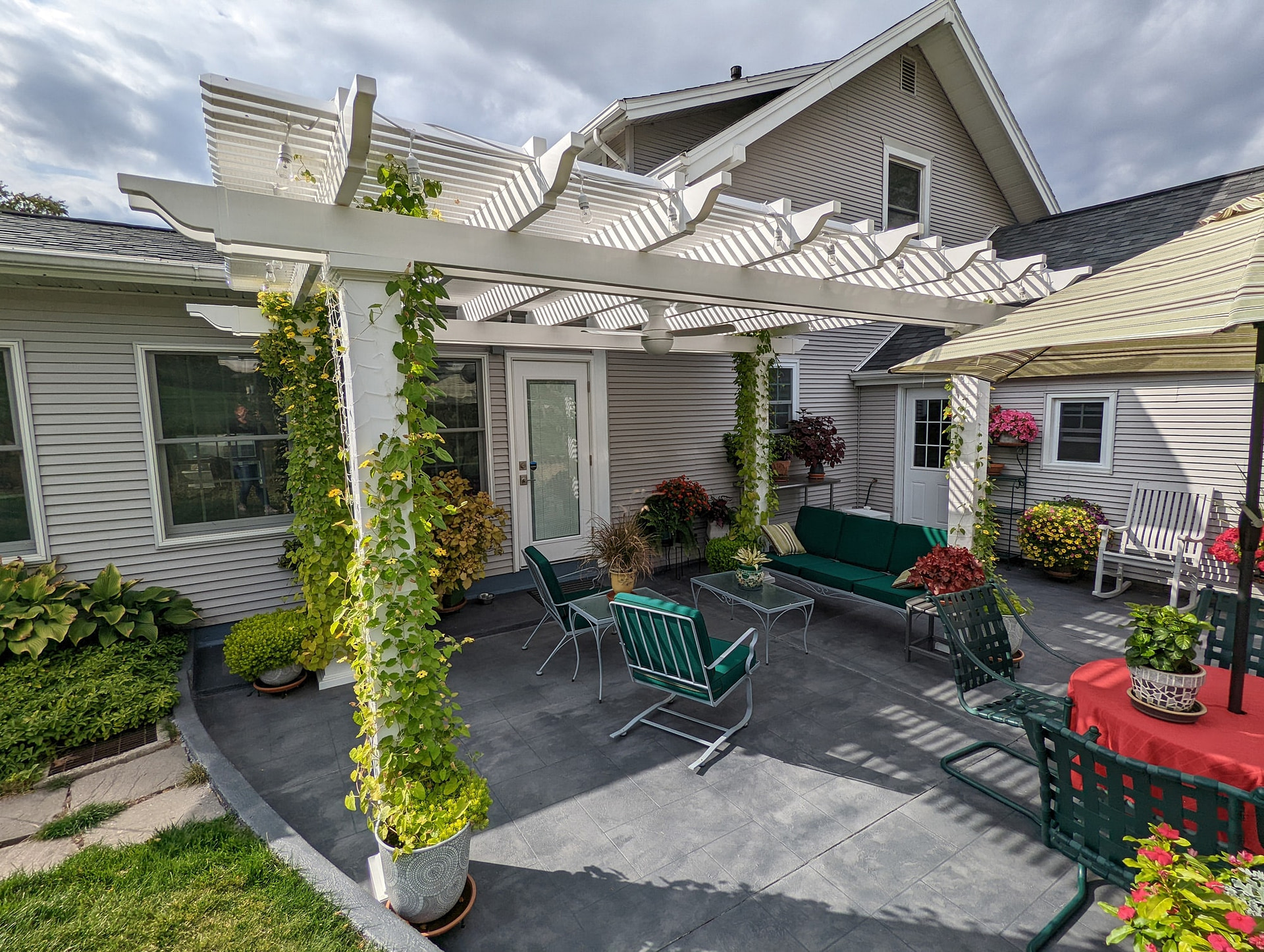 Freestanding vinyl pergola with vines growing up the posts