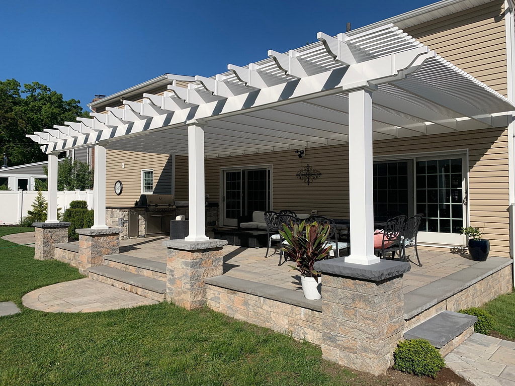 Large attached pergola with paver pillars over patio