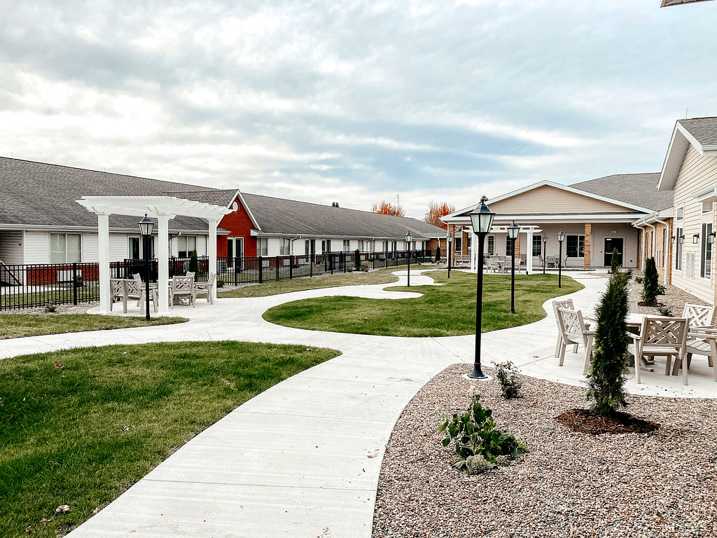 Liberty village senior living courtyard with shade pergolas along the walkway