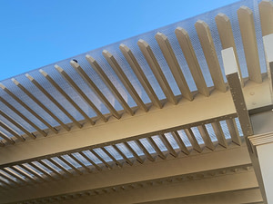 close up of pergola roof purlins with a clear polycarbonate sheet over top