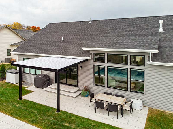 View from above a patio cover over stamped concrete pad on the back of a house.