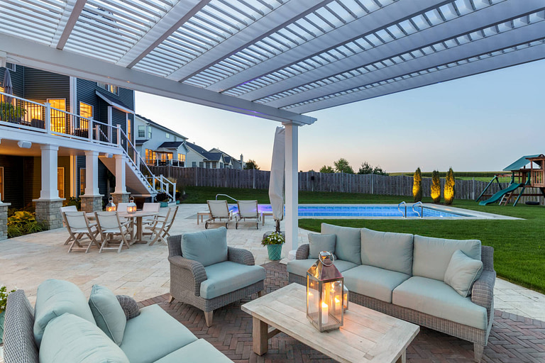 View from under a vinyl pergola nicely furnished at dusk