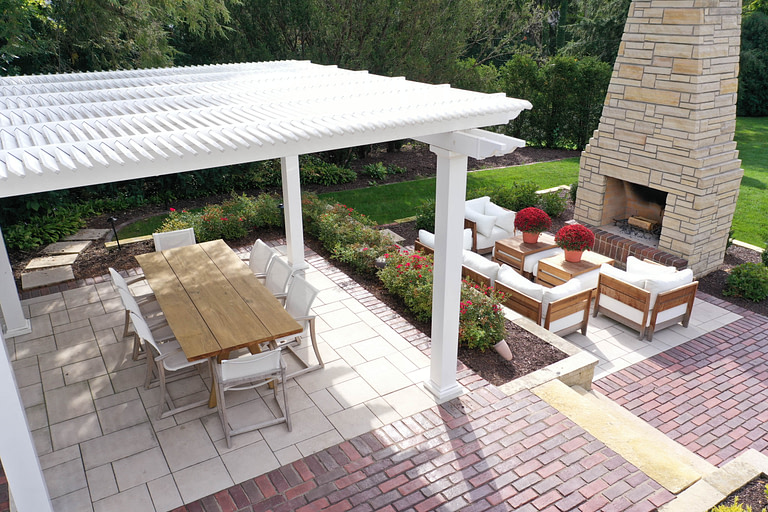 freestanding shade pergola next to outdoor fireplace