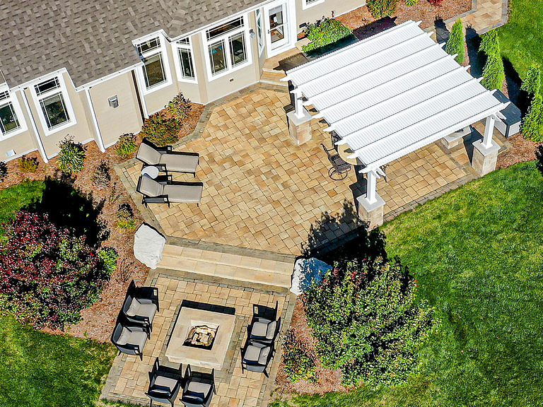 aerial view of landscaped backyard with stone work and pergola