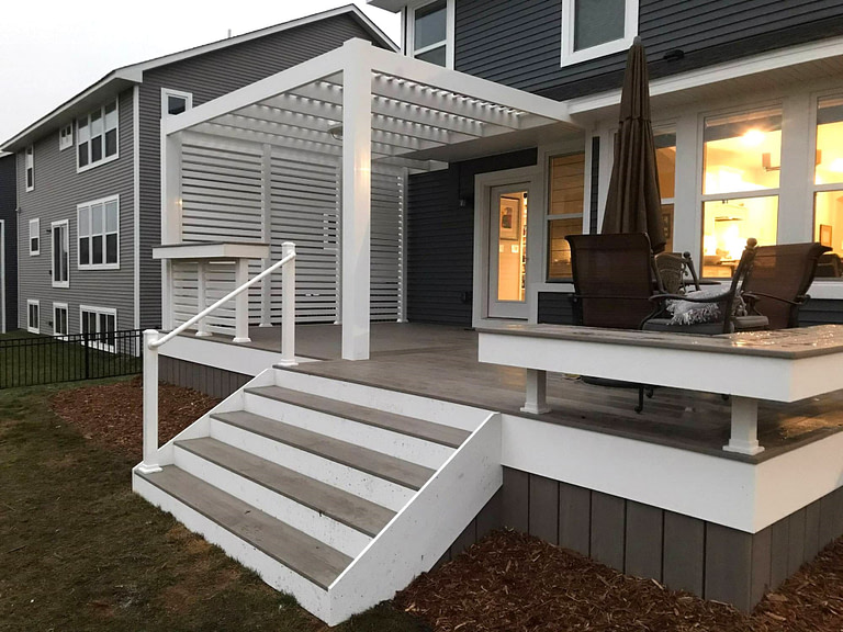 Attached modern white pergola over a deck with vinyl slat privacy wall