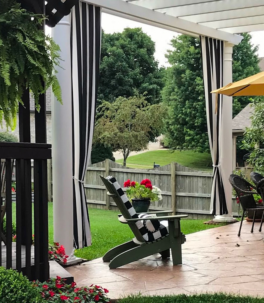 Pergola with long black and white outdoor curtains for privacy