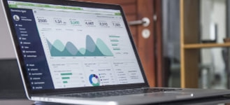 open laptop displaying charts atop table