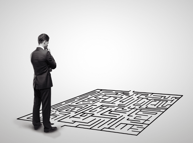 businessman thinking and looking down at a puzzle