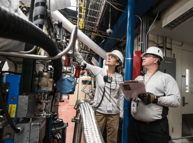 two factory workers evaluating factory machinery