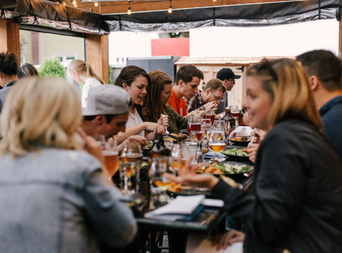 large group of people eating on outdoor patio in restaurant