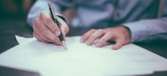 person writing reports with pen