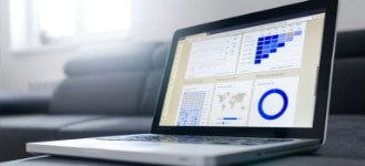 laptop with charts sitting atop coffee table