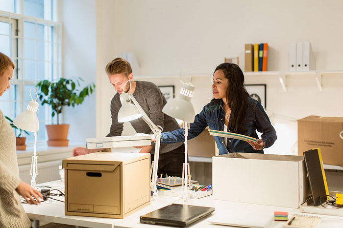 office workers package office items for move