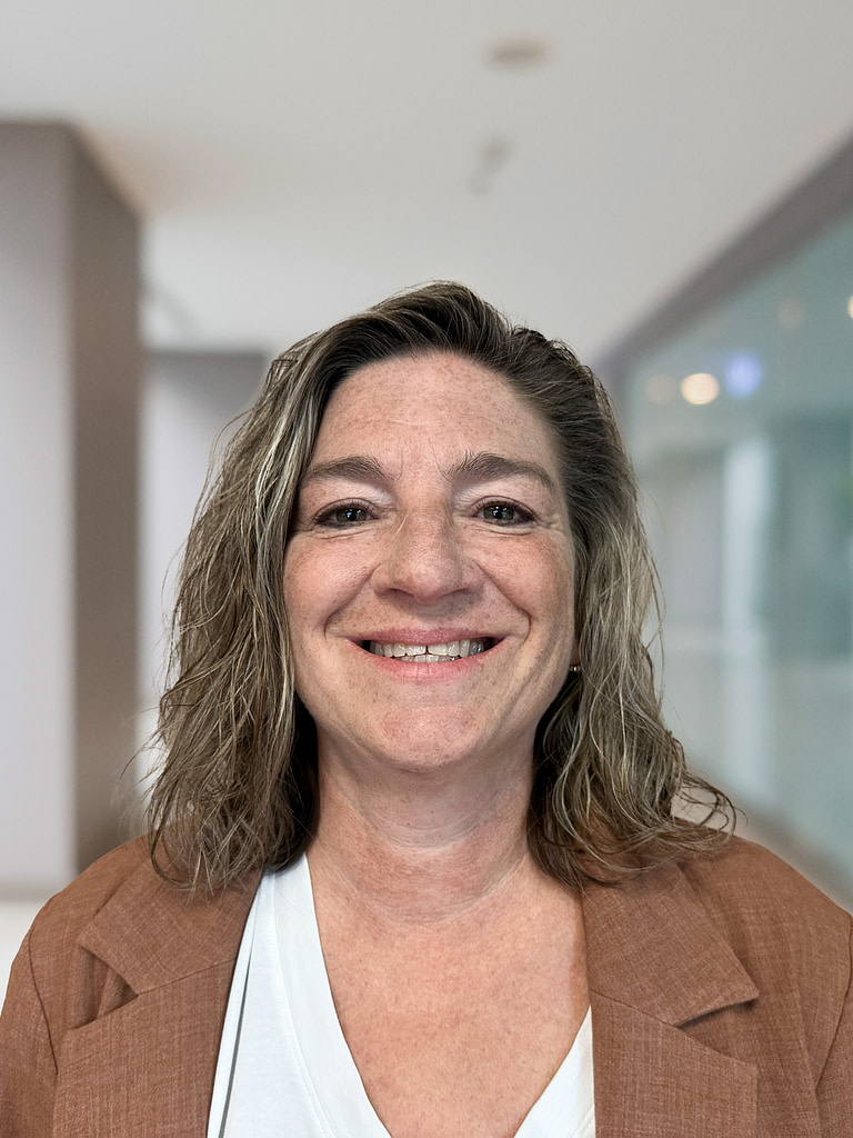 Smiling woman in brown blazer at office