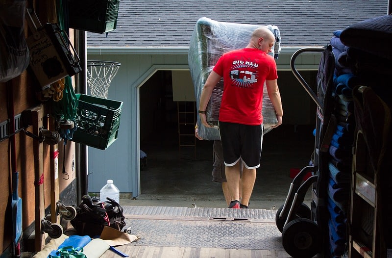 movers load a couch onto moving truck
