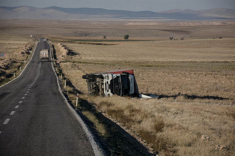 a truck driving down a dirt road