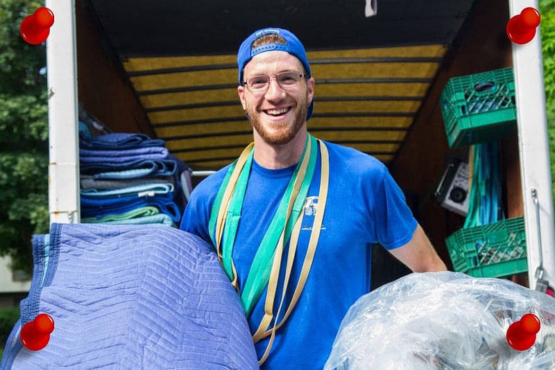 mover smiling and holding moving materials
