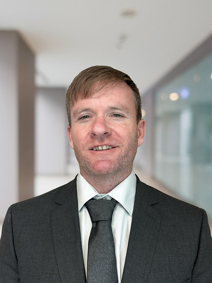 Businessman in suit smiling in office hallway