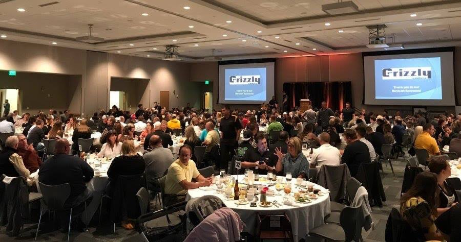 a group of people sitting at a table in front of a crowd