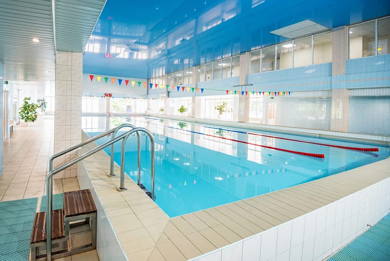 View Of Indoors Swimming Pool With Metal Ladder